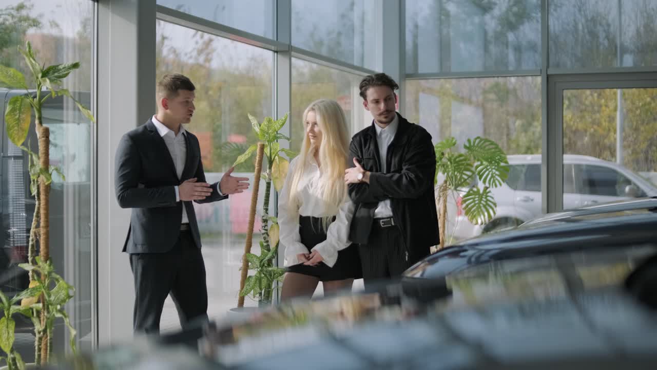 Car dealership salesman talking to a couple