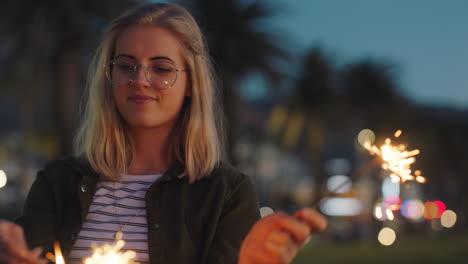 Fröhliches-Teenager-Mädchen,-Das-Bei-Sonnenuntergang-Am-Strand-Mit-Wunderkerzen-Spielt-Und-Spaß-Daran-Hat,-Silvester-Zu-Feiern.-Frau-Genießt-Die-Feierlichkeiten-Zum-Unabhängigkeitstag-Mit-Feuerwerk