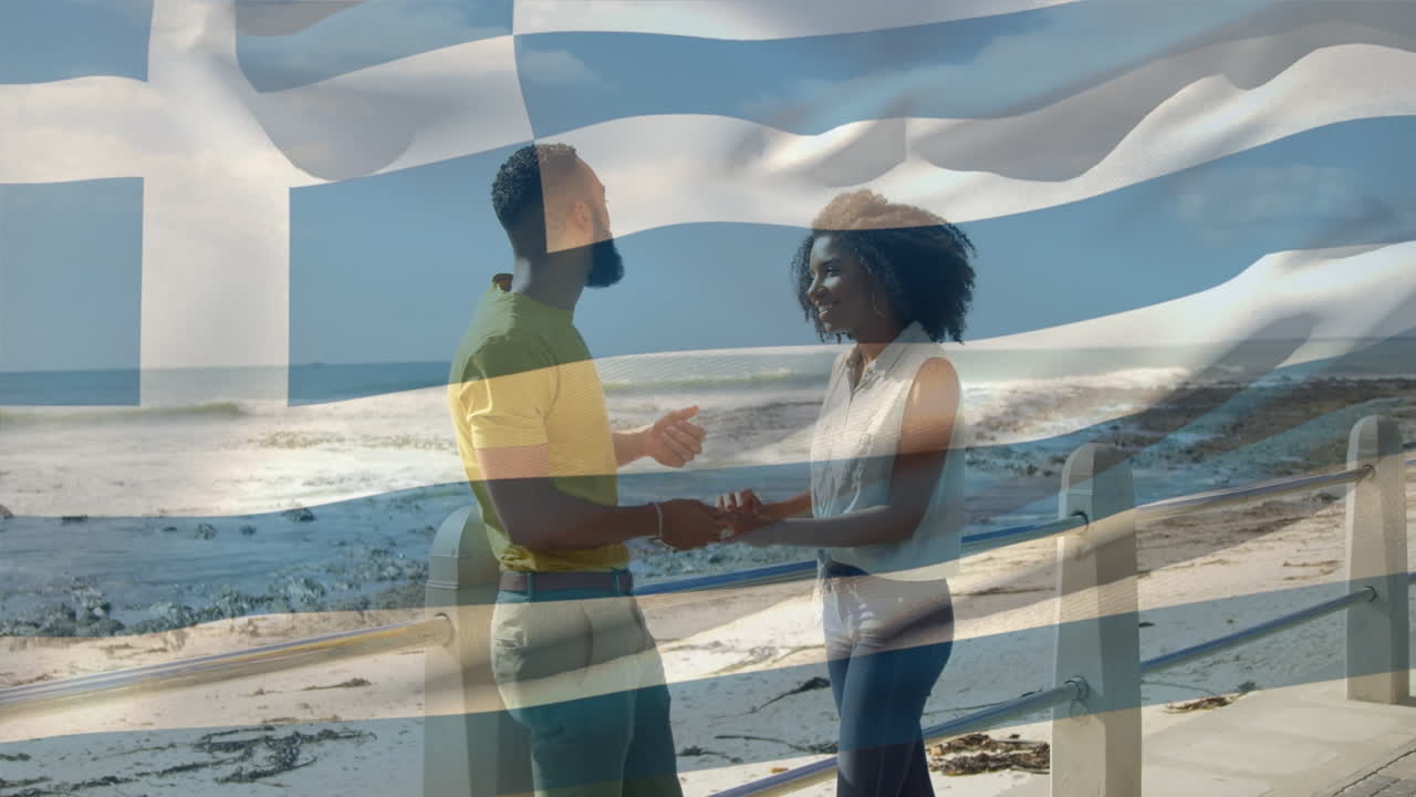 animación de la bandera de grecia sobre una pareja afroamericana en la playa