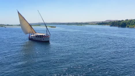 aerial drone shot of a sailing ship navigating through nile river as a tourist cruise