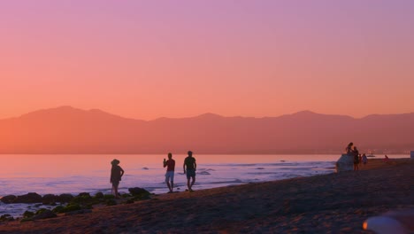 gente en la playa al atardecer