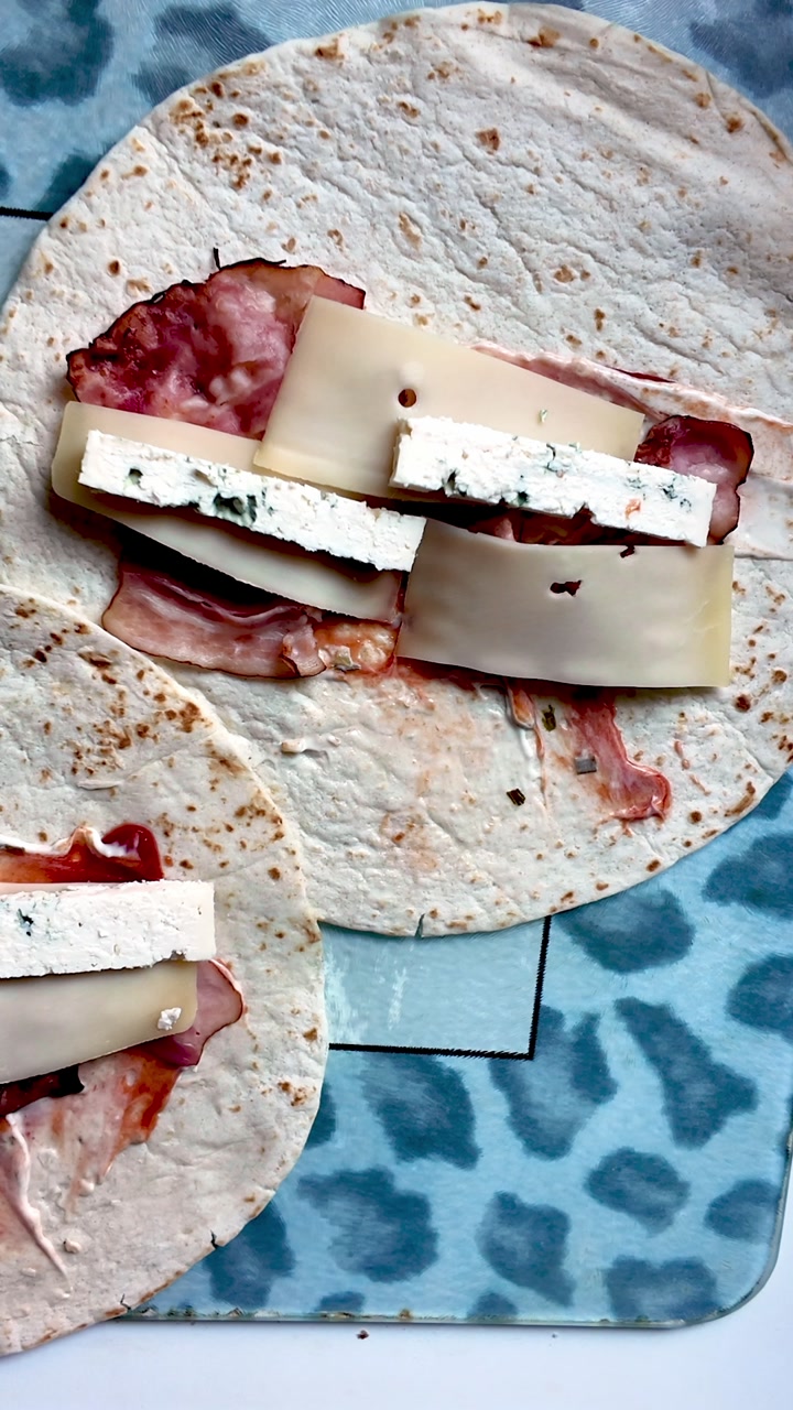 Filling Tortilla wrap with cheeses and meat for tasty appetizing snack lunch