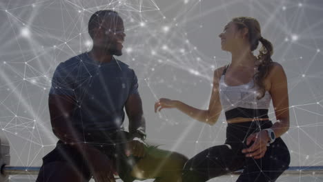 network of connections against biracial couple talking to each other sitting near the beach