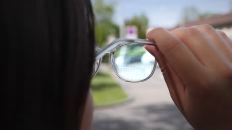 young woman looks through modern augmented reality glasses with digital display