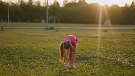 little girl waves off insects from bare legs on field