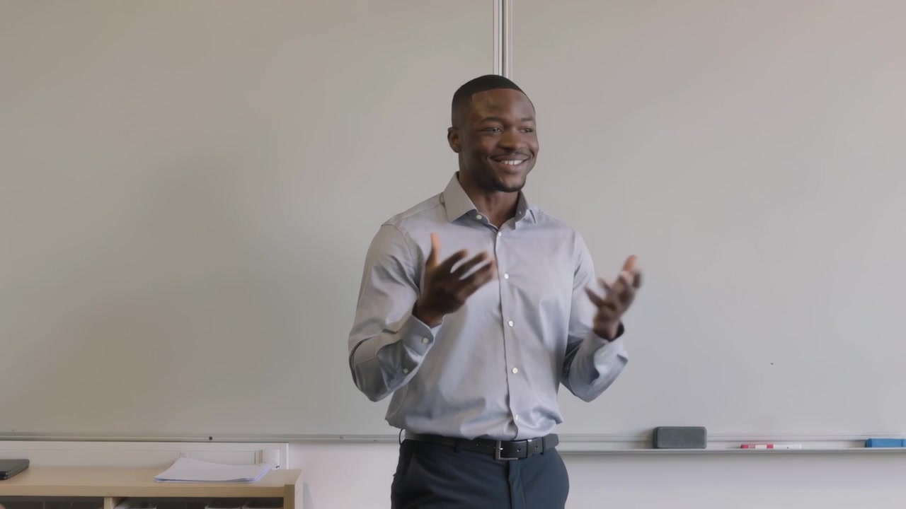 Addressing teacher in light shirt, starting class, teaching and gesturing at front with whiteboard