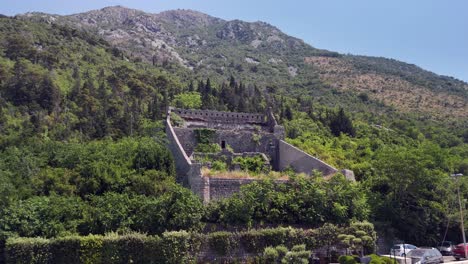 flyover holy cross fort ruins on hillside above perast, montenegro