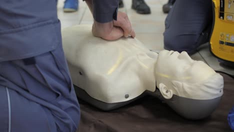 first aid cardiopulmonary resuscitation training demonstration, closeup, handheld