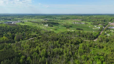 wide drone view of golf course and forest in sunny ontario, canada