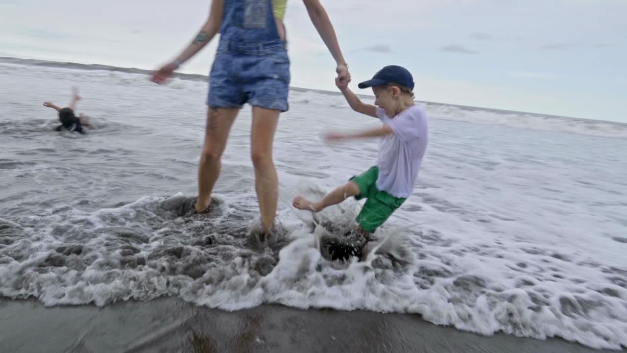 niños pequeños jugando en las olas del océano