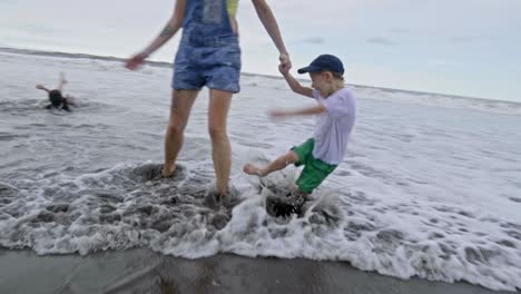 niños pequeños jugando en las olas del océano