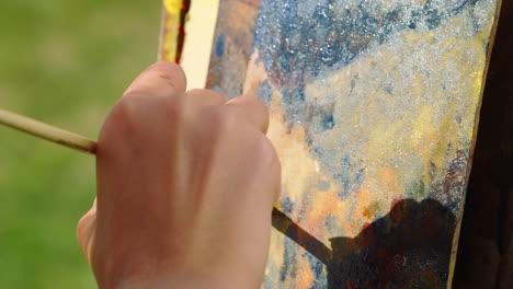 Closeup-hand-painter-creating-masterpiece-at-summer-day.-Craft-art-concept