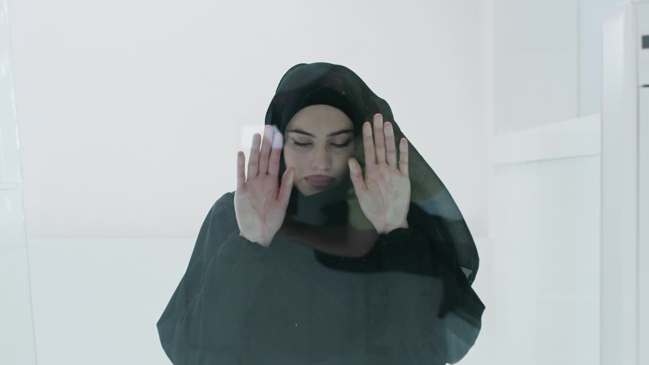 Middle eastern arab muslim woman in traditional hijab clothes praying on the glass floor