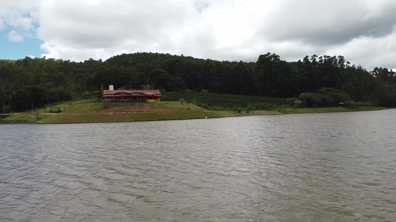 vuelo aéreo bajo sobre el lago, acercándose persona irreconocible navegando en kayak