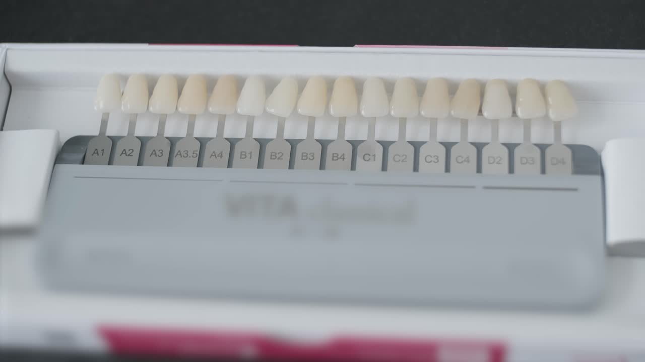 Palette of shades of teeth scale vita. A tool for teeth whitening isolate on a gray background.