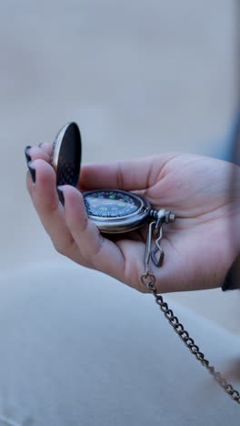 a hand holding an antique compass