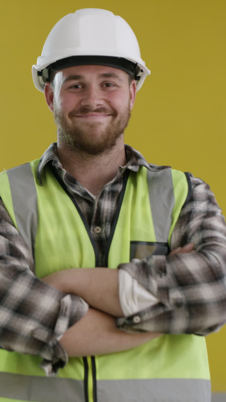 Giovane operaio edile con casco e giubbotto di sicurezza sorridente