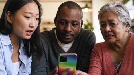 a multigenerational group engaged in conversation over a smartphone, sharing moments of technology and connection in a cozy environment