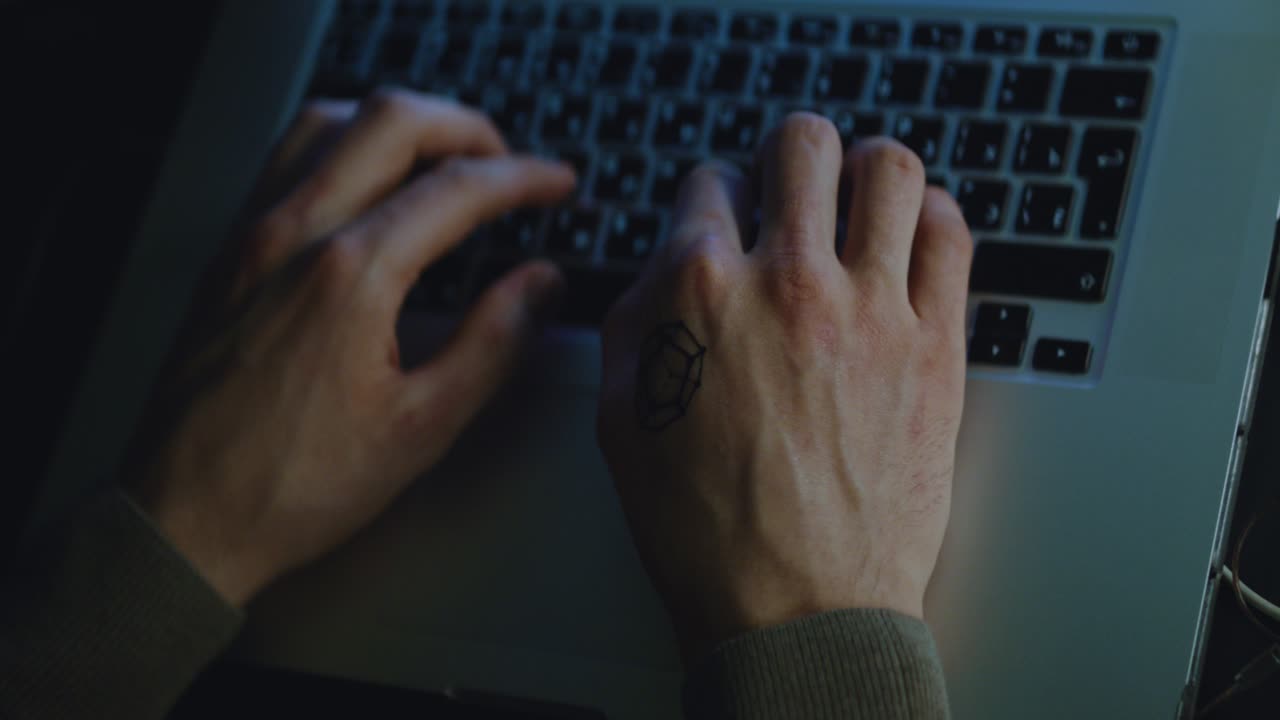 Person typing on a laptop at night