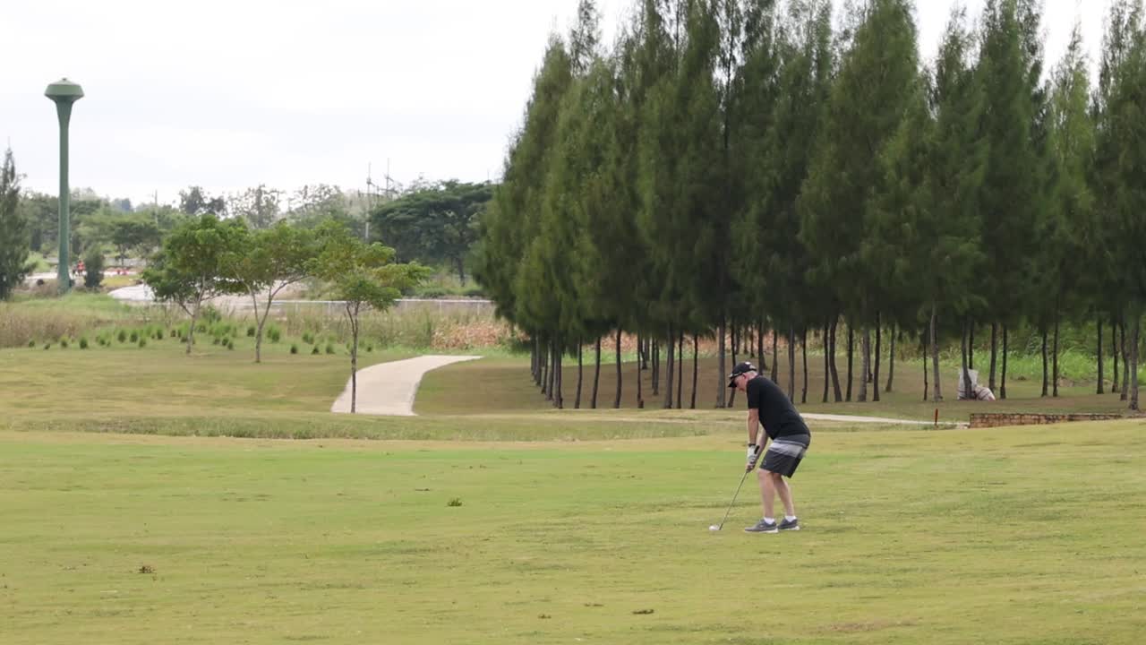 A golfer focuses on perfecting their swing amidst a serene golf course setting with lush greenery.