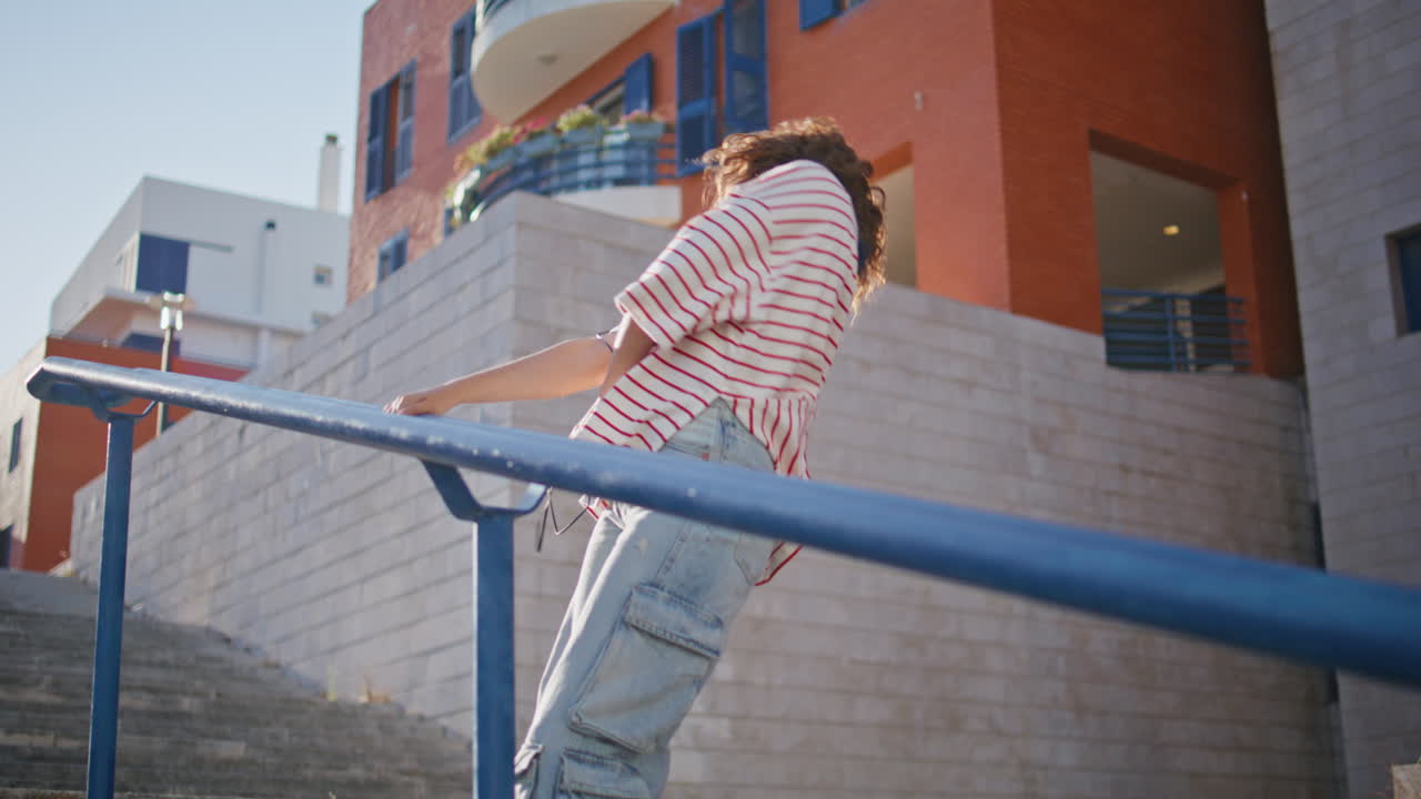 adolescente elegante bailando escaleras escuchando música en auriculares. bailarín feliz moviéndose