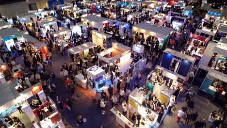 aerial view of a bustling trade show with numerous booths and attendees