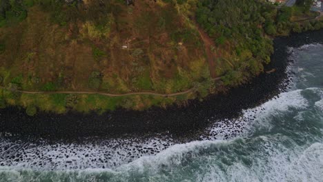 ocean waves crashing at the basalt rocks on the foot of burleigh headland in qld, australia