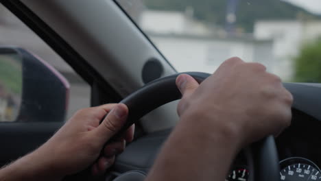 close-up of hands on steering wheel while driving