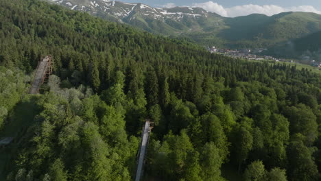 three ski jump ramps on lush green forest mountain in bakuriani ski resort in georgia