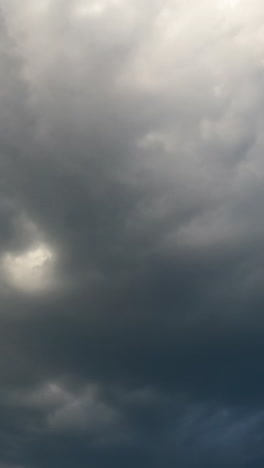 grey rainy clouds spreading by the sky. rain formation in the atmosphere. low angle view timelapse. vertical video