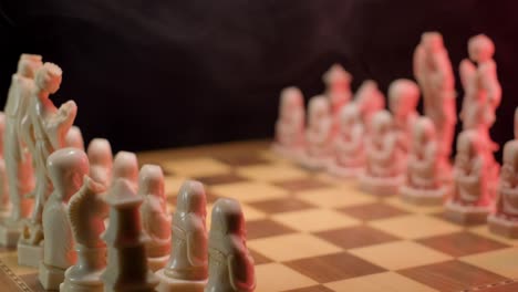 a close up dolly shot tracking in towards the chequered squares of a wooden chessboard, the pieces are placed ready and set the scene for a new chess match to begin