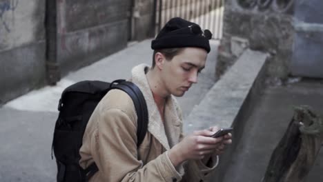 young man writing sms on his mobile phone