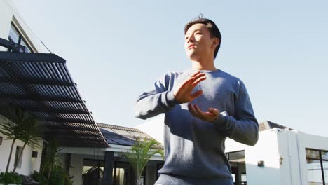 video of relaxed biracial man exercising tai chi in garden