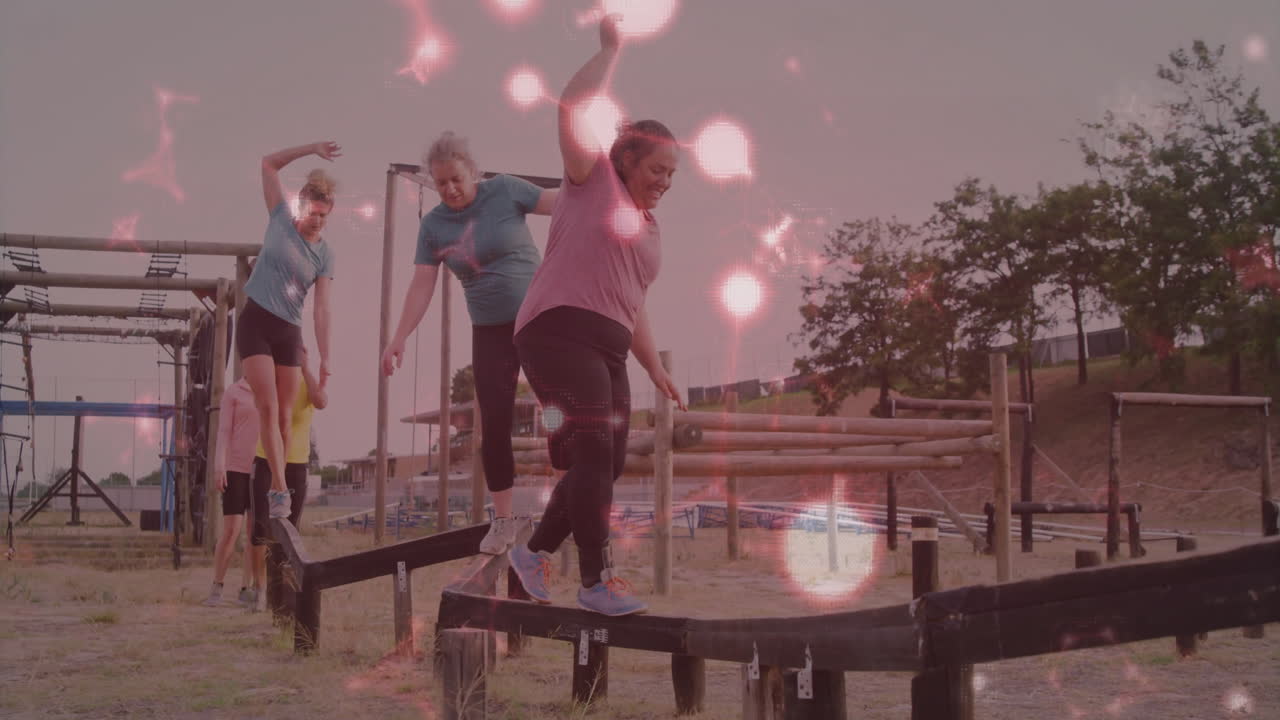 People balancing on outdoor obstacle course with glowing light animation overlay