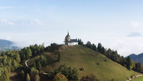 Aerial-view-of-the-Hills,-Mountains,-Colorful-Forest,-and-the-Church-of-Sv