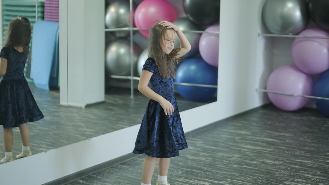 Bambina che fa stretching e riscaldamento in uno studio di danza