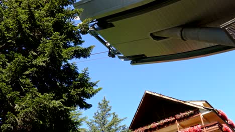 cable car in motion next to a building.