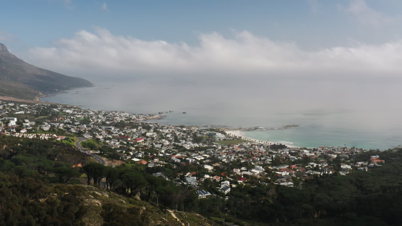 Drone Shot revealing Camps Bay along the coast of Cape Town, South Africa