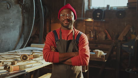 portrait of smiling african american blacksmith in his workshop