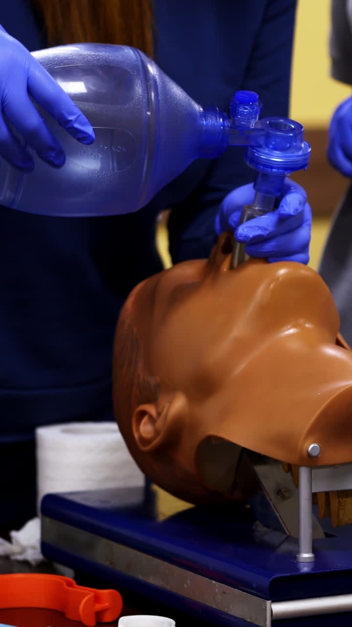 Training session of giving first aid. Person does the training reanimation procedure on a dummy with breathing system. Vertical video
