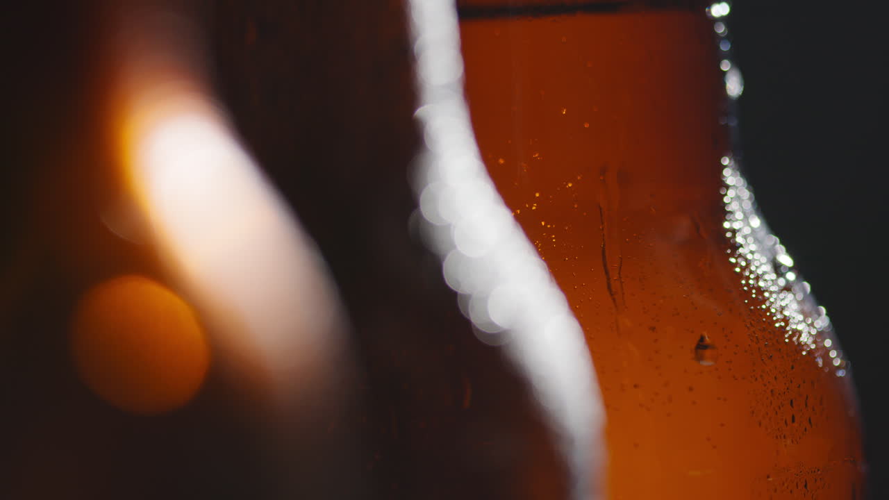 Close Up Of Condensation Droplets Running Down Bottles Of Cold Beer Or Soft Drinks