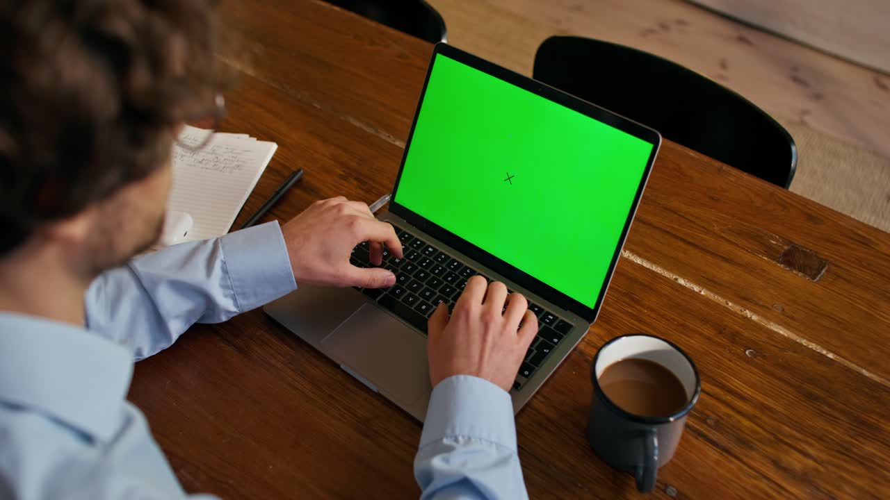 persona que trabaja en una computadora portátil con pantalla verde