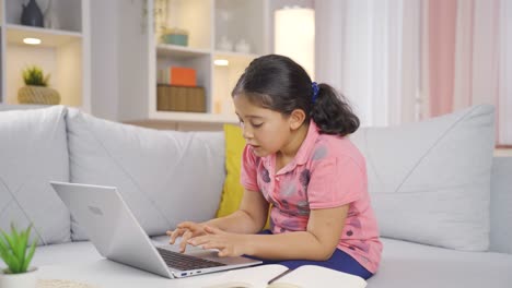 una niña mirando la computadora portátil con asombro.