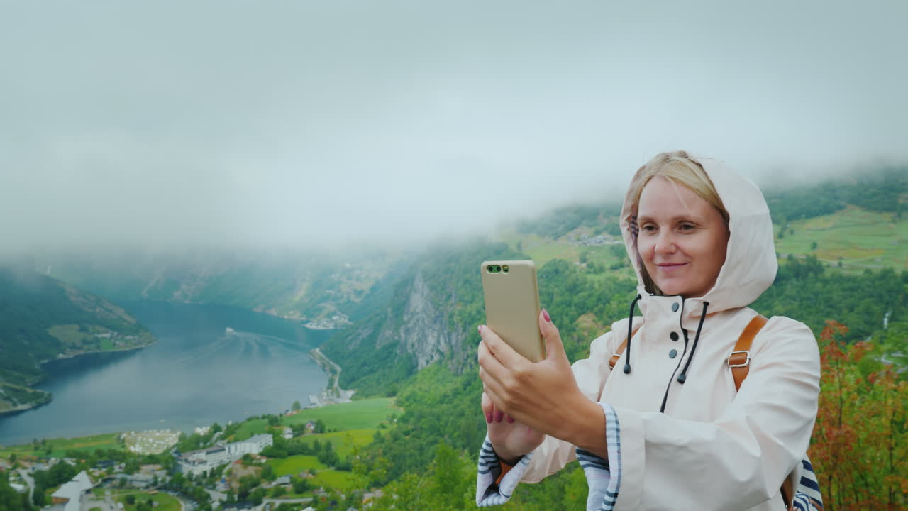 un turista feliz es fotografiado en el contexto de un pintoresco fiordo en noruega vale la pena