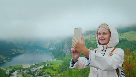 a happy tourist is photographed against the background of a picturesque fjord in norway it is worth