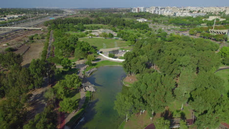 el parque herzliya, israel tiene un pequeño estanque, restaurantes, patios de juegos para niños, pistas para correr, pistas para bicicletas y patio de juegos para perros