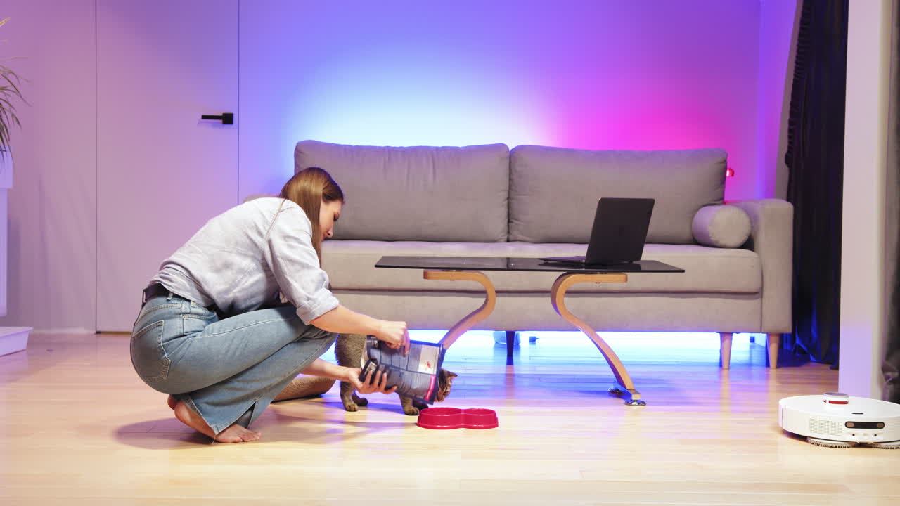 거실 에서 고양이 를 먹이는 여자