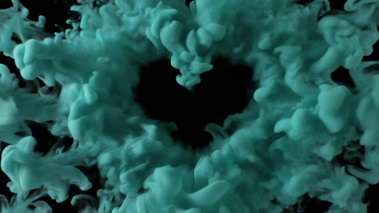 Nuvola di inchiostro verde acqua che forma un cuore nell'acqua