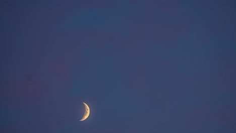 timelapse shot of beautiful crescent moon moving isolated against dark black sky background at night time