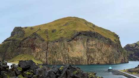 massive coastal rock steep cliffs at vestmannaeyjar (westman islands) in iceland. static shot